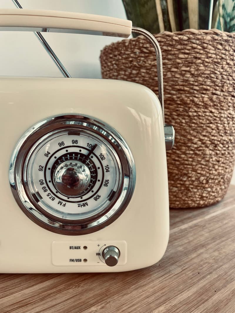 Close-up of a vintage-style radio dial next to a woven basket